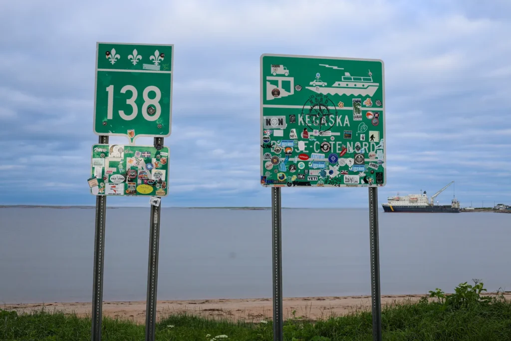 Panneaux couverts d'autocollants au bout de la route 138 à Kegaska, sur la Côte-Nord, où le réseau cellulaire se fait rare