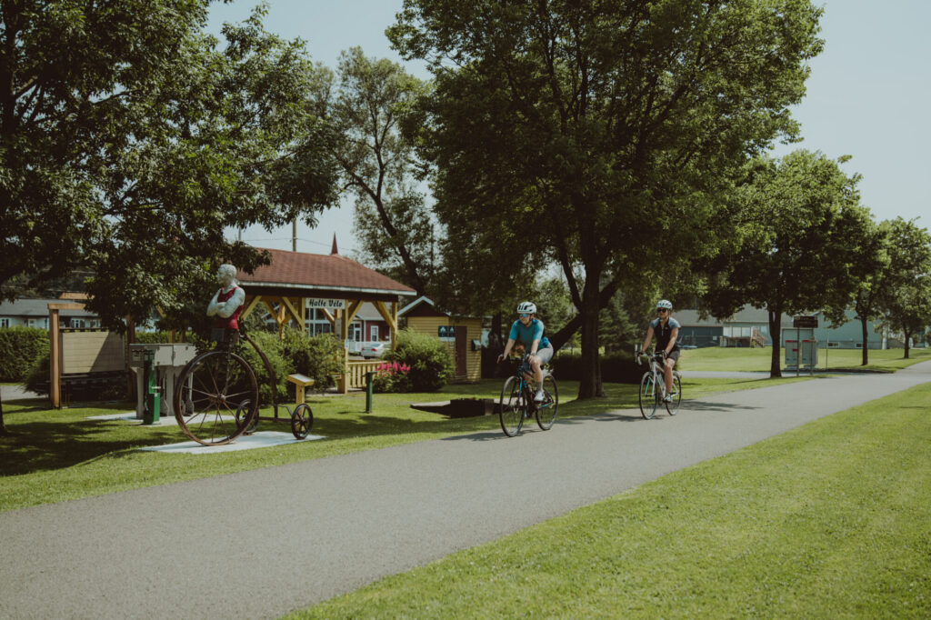 Cyclistes sur une piste cyclable asphaltée dans un village de Lotbinière