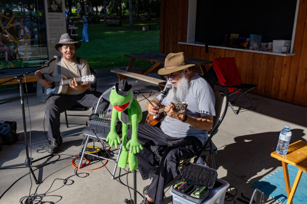 Duo de musiciens et marionnette de grenouille au Marché public de Compton