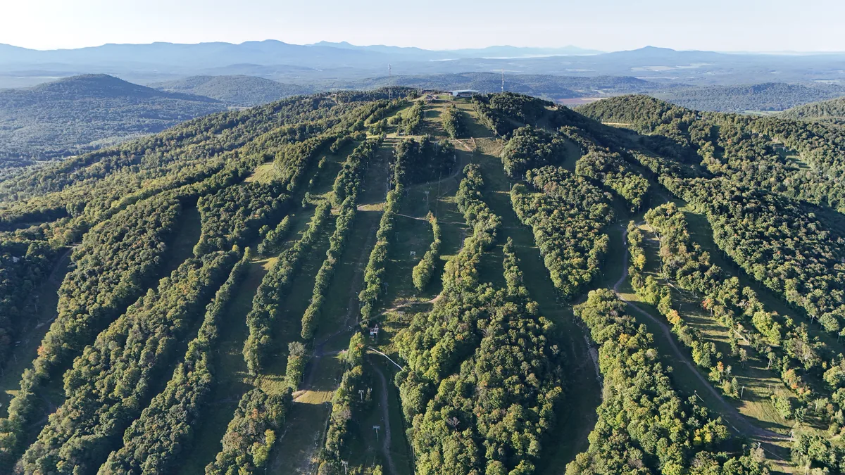 Mont Brome vu des airs à Bromont, sur la Route des Vins : pistes de ski gazonnées, forêt et montagnes des Cantons en été