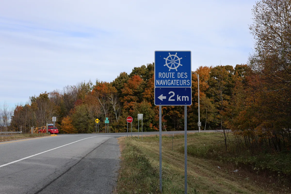 Route bordée d'arbres orangés et panneau de la Route des Navigateurs à Saint-Michel-de-Bellechasse
