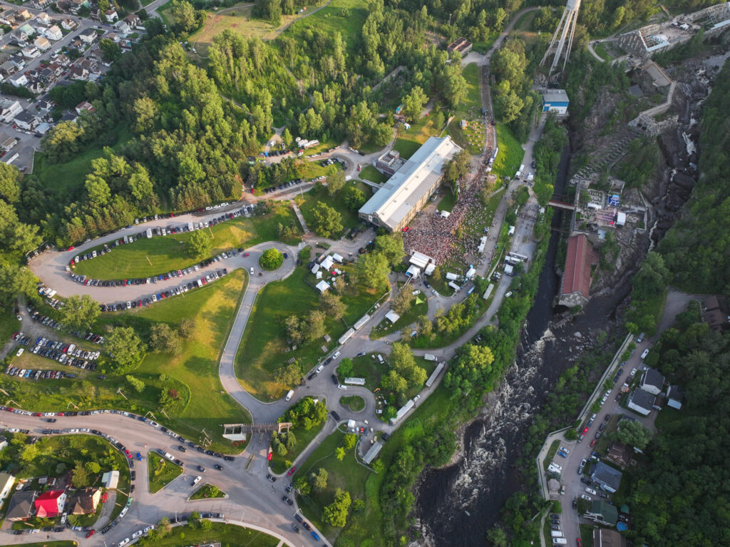 Vue aérienne verticale des stationnements remplis et de la foule du festival La Noce à la Pulperie de Chicoutimi