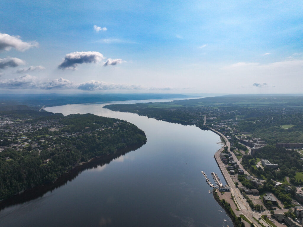 Vue aérienne en altitude de la rivière Saguenay vers le fjord, avec Chicoutimi et sa marina