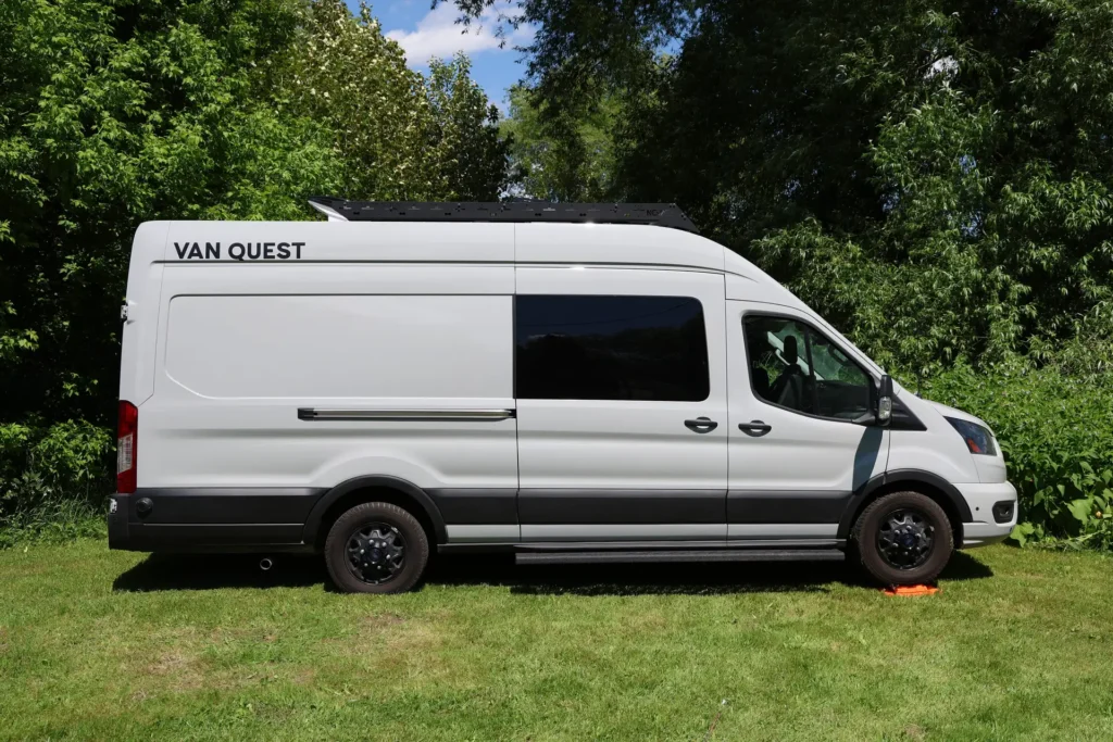 Un fourgon aménagé garé sur l'herbe, prêt pour une nuit sur la Route des Monts Notre-Dame