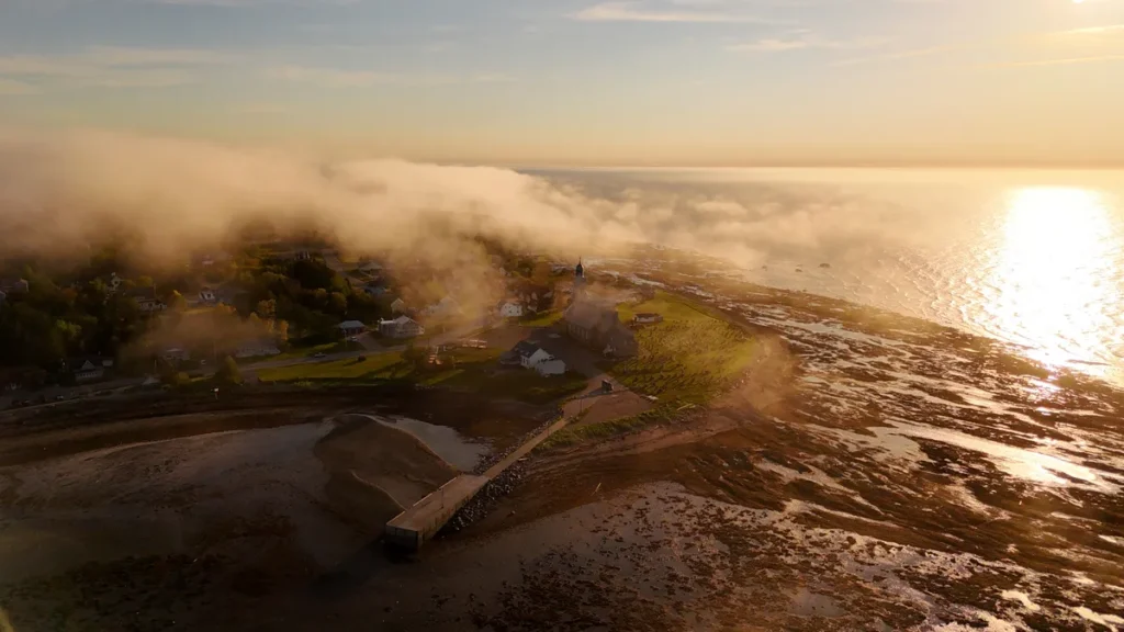 Vue aérienne de la brume qui roule sur la batture et le quai de Sainte-Luce, départ de la Route des Monts Notre-Dame