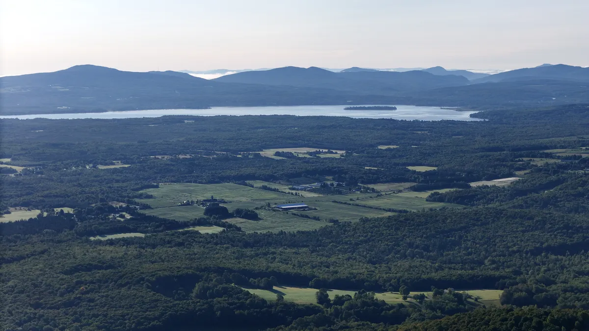 Route des Vins en 2 jours : vue aérienne vers le sud depuis Bromont, campagne boisée et grand lac à l'horizon