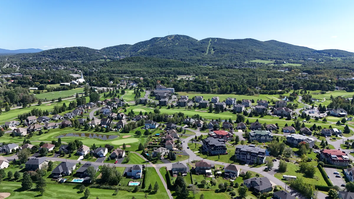 Route des Vins près de Bromont : vue aérienne d'un quartier résidentiel et du mont Brome avec ses pistes, en été