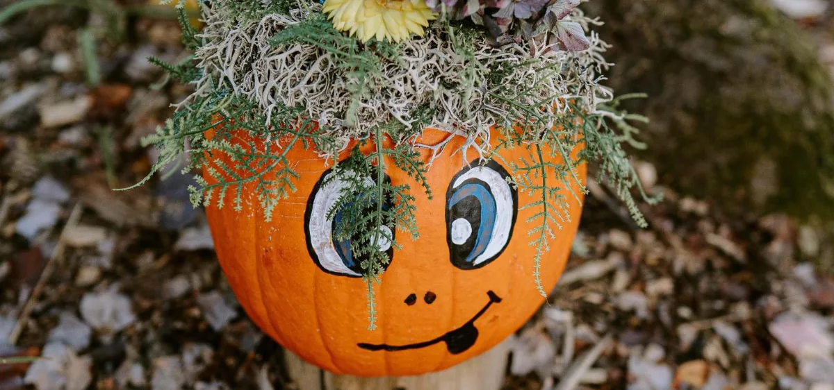 Citrouille décorée d'un visage souriant et coiffée de fleurs séchées au Jardin des citrouilles du Jardin Moore, à Mascouche