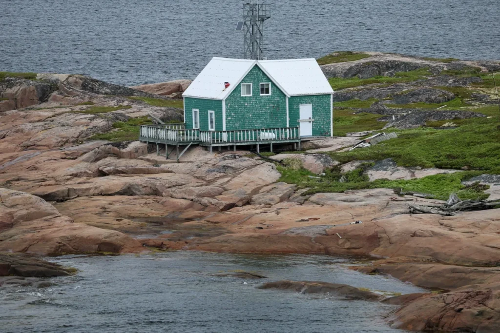 Maison verte sur les rochers roses de Harrington Harbour, en Basse-Côte-Nord