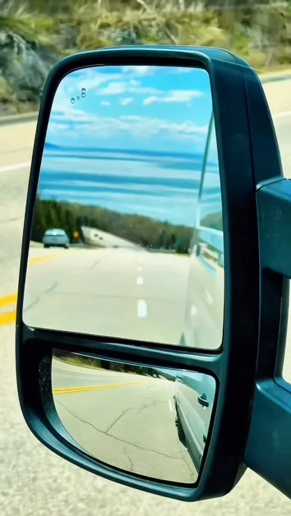 Le fleuve et la route 138 dans Charlevoix, vus dans le rétroviseur d'un van