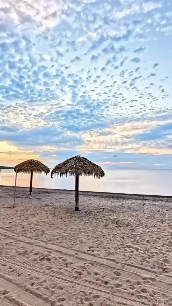 Plage de sable et parasols de paille au Lac-Saint-Jean