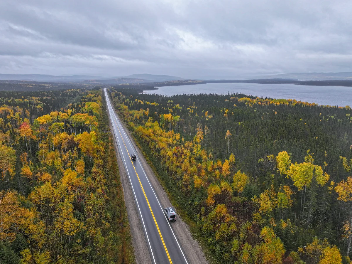 Véhicules sur la route 167 au milieu des feuillus jaunes de la réserve faunique Ashuapmushuan