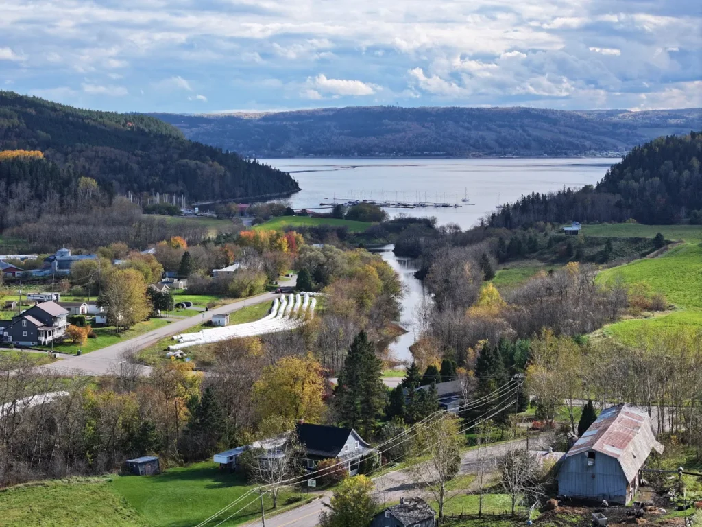 Road trip au Québec : village au bord du fjord du Saguenay, entre collines colorées et marina, en automne