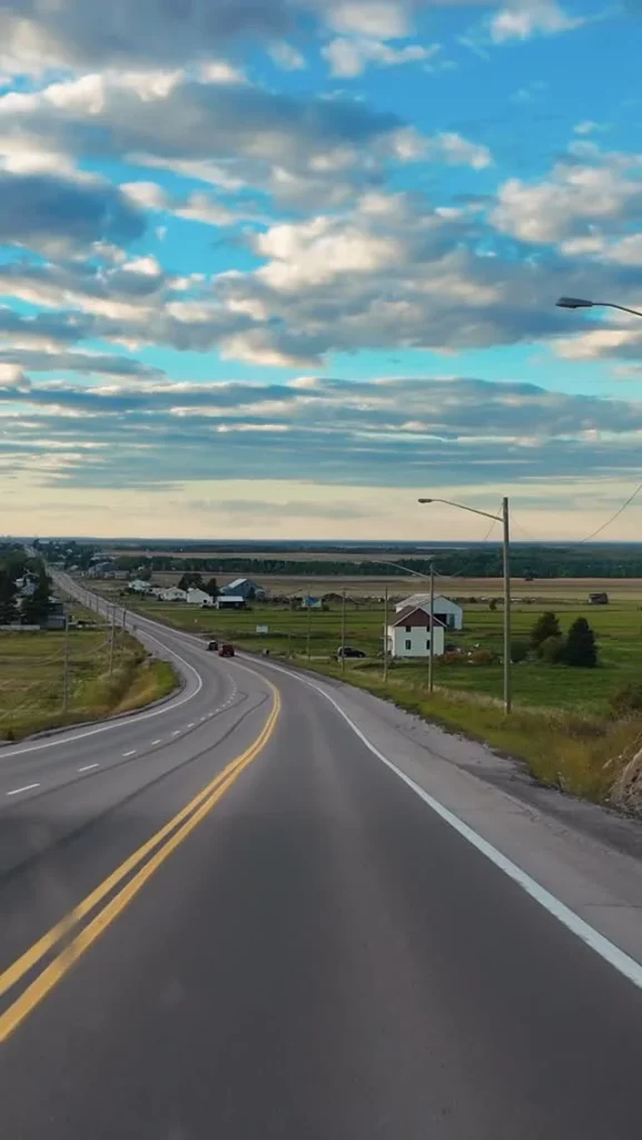 Route qui longe le lac Saint-Jean sous un ciel nuageux