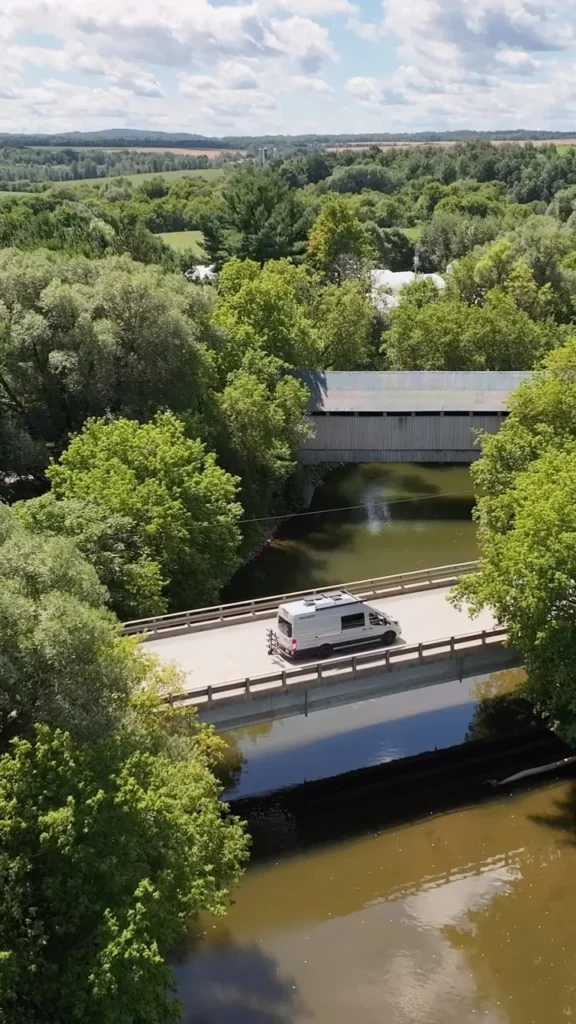 Van traversant un pont près d'un pont couvert sur le Chemin des Cantons